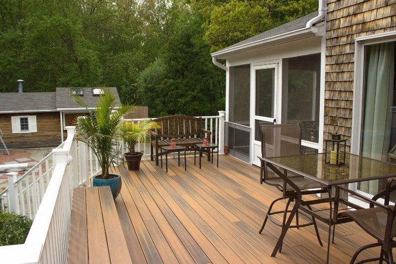 Plastic composite deck area in a residential property. The plastform has a white timber balustrade