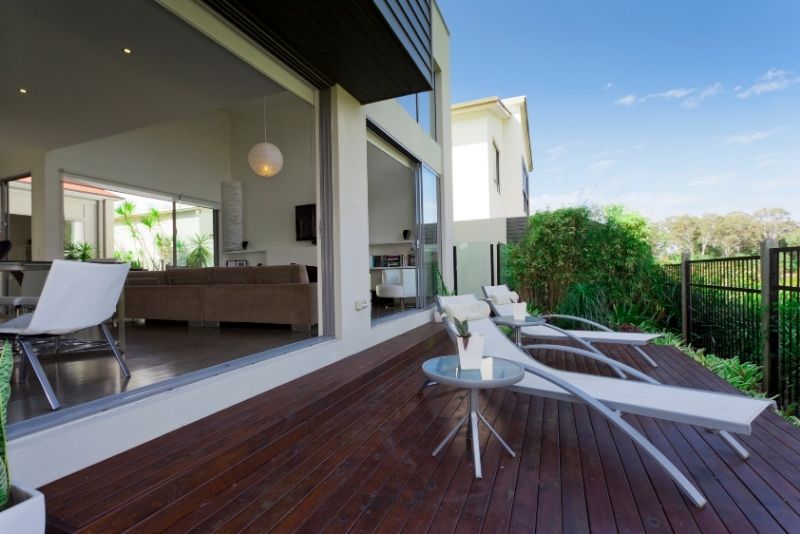Exterior hardwood decking area in Newcastle. There is also outdoor pool chairs and a table next to it