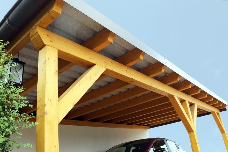 sngle car-spaced carport sheds besides the building