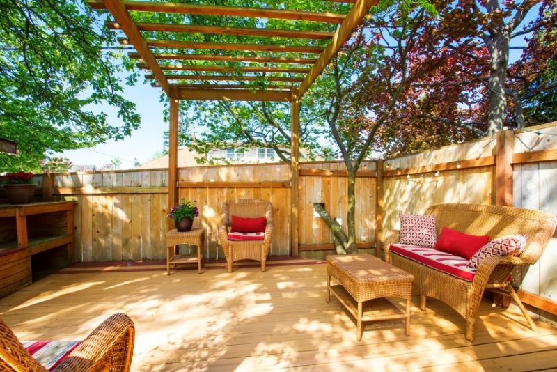 shady ooutdoor living room extension with deck and pergola
